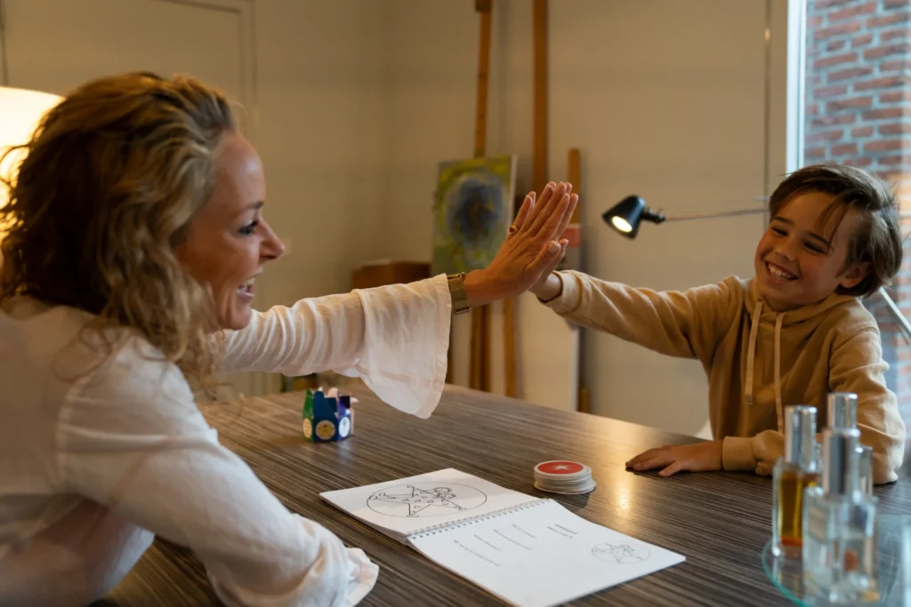 Michelle Storimans geeft een kind een high-five tijdens een therapie sessie